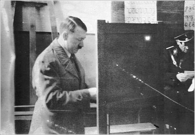 Adolf Hitler casts his vote at a Berlin polling station set up in a schoolroom. (March 1933)